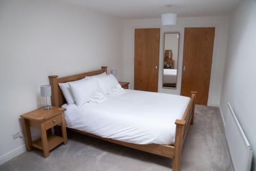 a bedroom with a large white bed and a table at Low Haven in Keswick