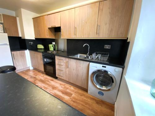 cocina con lavadora y fregadero en Cosy, Modern 2 Bedroom Apartment in the Centre of Inveraray, en Inveraray