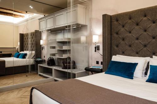 a hotel room with a large bed with blue pillows at Hotel Pjazza Merkanti - Boutique Living in Valletta