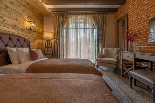 a bedroom with two beds and a chair and a window at Bengodi Boutique Hotel in Eceabat