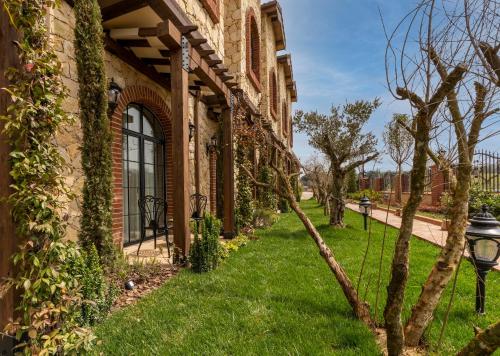 a house with a green yard next to a building at Bengodi Boutique Hotel in Eceabat