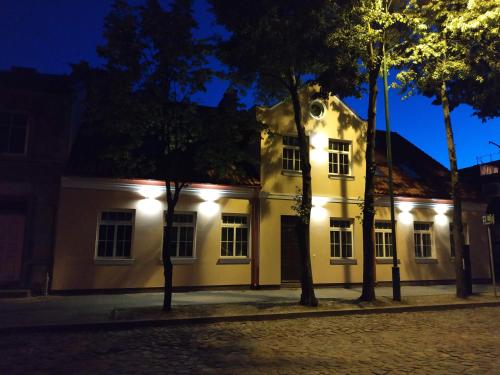 a white building with lights on it at night at Apartamentai Puodžių 27 in Klaipėda
