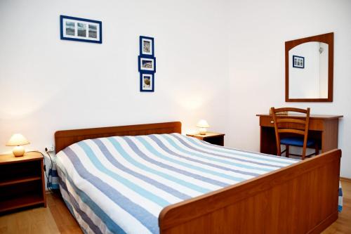 a bedroom with a bed and a desk and a chair at apartmani Novotny plavi in Banjol