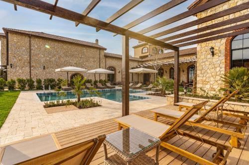 a patio with tables and chairs and a pool at Bengodi Boutique Hotel in Eceabat
