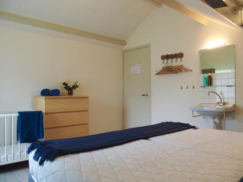 1 dormitorio con 1 cama grande y lavamanos en Vakantiehuis Zee in zicht, en Renesse