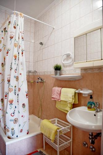 a bathroom with a shower curtain and a sink at apartmani Novotny plavi in Banjol