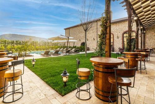 a patio with tables and bar stools and a garden at Bengodi Boutique Hotel in Eceabat