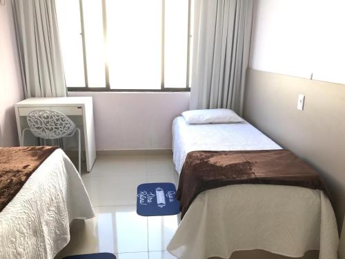 a small room with two beds and a tv at Atlantico Flat Ap. 107 in Natal