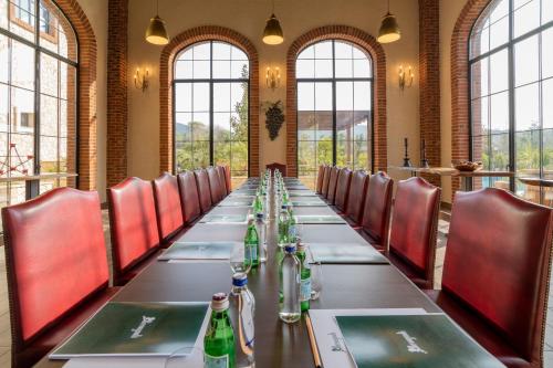a long table in a room with chairs and bottles at Bengodi Boutique Hotel in Eceabat