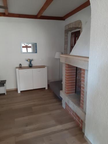 a living room with a brick fireplace and a table at Apartment Mamut in Premantura