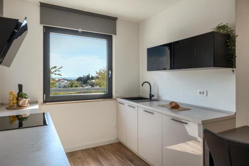 a kitchen with white cabinets and a window at Belvedere Holidays in Novigrad Istria