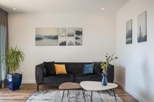 a living room with a black couch and a table at Belvedere Holidays in Novigrad Istria