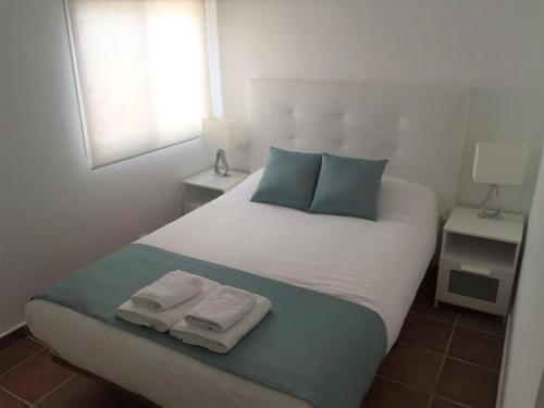 een slaapkamer met een groot bed met twee handdoeken erop bij Casa Oliva Playa Bolonia in Tarifa