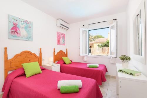 two beds in a room with red sheets and a window at Villa Carianne by Villa Plus in Son Carrio