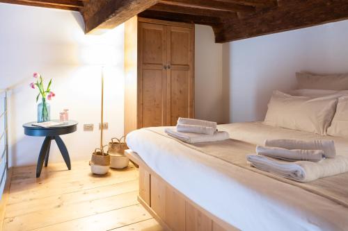 1 dormitorio con 1 cama grande y toallas. en LEI Luxury Suite en San Miniato