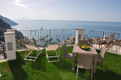 einen Tisch und Stühle auf einem Balkon mit Meerblick in der Unterkunft Casa Roberta in Positano