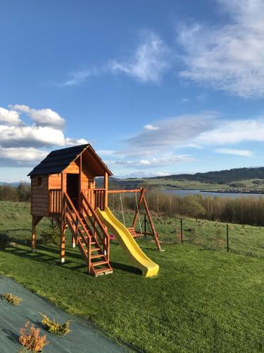 a playground with a slide and a play house at Domek na Hubce 1 in Maniowy