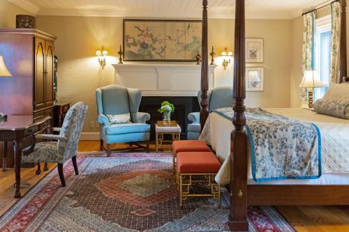 a bedroom with a bed and a desk and chairs at Arrowhead Inn in Durham
