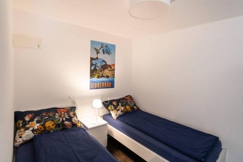 - une chambre avec 2 lits et une photo sur le mur dans l'établissement Cristal 28, à Loèche-les-Bains