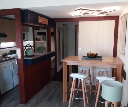 cocina con barra de madera y taburetes en Ker Lomic, en Arzon