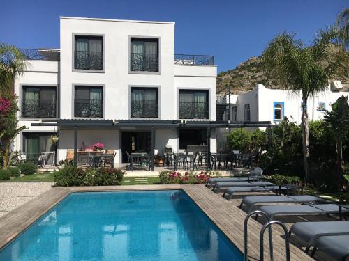 Villa Oliva Butik Hotel في بودروم: فندق فيه مسبح ومبنى