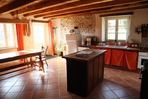 Una cocina con un refrigerador y una mesa dentro. en Gîte de la Barlière, en Secondigny