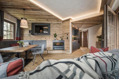 a living room with a table and a fireplace at Aparthotel Stacherhof in Fügen