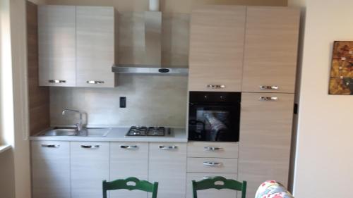 uma cozinha com armários brancos e um lavatório em azalea apartments domo2 em Baveno