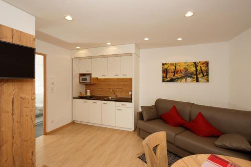 a living room with a couch and a kitchen at Hotel/ App. Garber in San Giacomo