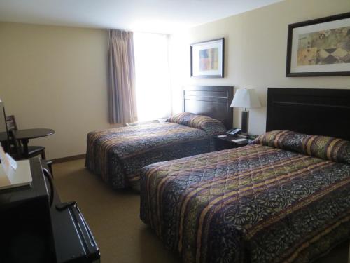 a hotel room with two beds and a window at New Lodge Winnipeg in Winnipeg