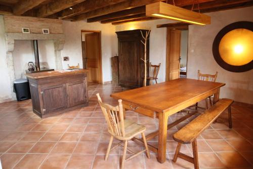 Una cocina y un comedor con mesa y sillas de madera. en Gîte de la Barlière, en Secondigny