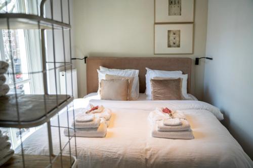 een slaapkamer met een bed met handdoeken erop bij Ginny's studio op de Grote Markt in Breda