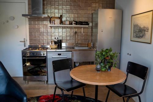 a kitchen with a table and a sink and a stove at Ginny's studio op de Grote Markt in Breda