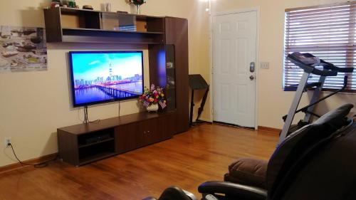 a living room with a flat screen tv on a entertainment center at House 3br 1-bath, 8-min from Indian Rocks Beach, nice park thru back gate in Largo
