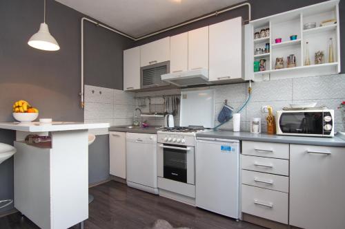 a kitchen with white cabinets and a microwave at Apartment Amra in Visoko