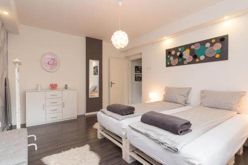 a bedroom with two beds and a chandelier at Apartment Amra in Visoko