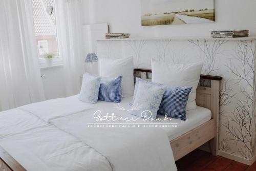 a bedroom with a bed with blue and white pillows at Ferienwohnung "Gott sei Dank" in Herzberg am Harz