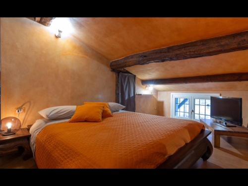 a bedroom with a bed and a television in it at Bea Ducale in Vigevano