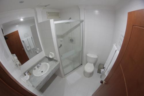 y baño con ducha, lavabo y aseo. en Vajamar Hotel, en Valledupar