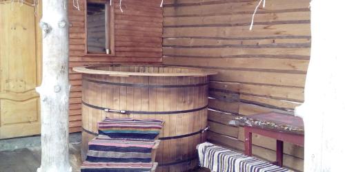 a wooden sauna with a wooden barrel and two towels at Готель Людмила in Synevyr