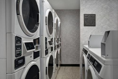 a row of washers and dryers in a laundry room at Staybridge Suites - Houston - Galleria Area, an IHG Hotel in Houston