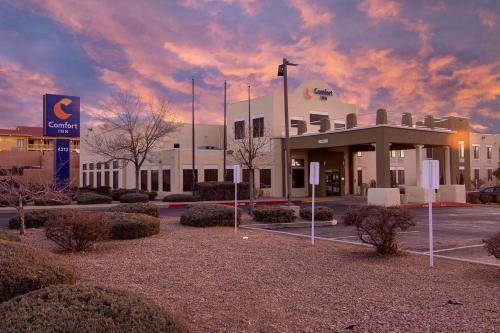 a building with a cloudy sky in a parking lot at Comfort Inn in Santa Fe