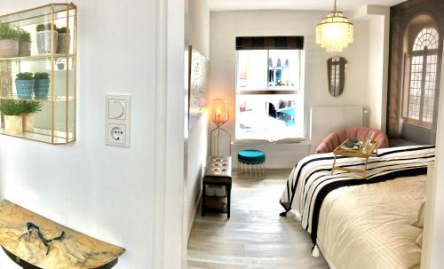 a bedroom with a bed and a window at Zonnige frisse studio De Gouden Parel in hartje Middelburg in Middelburg