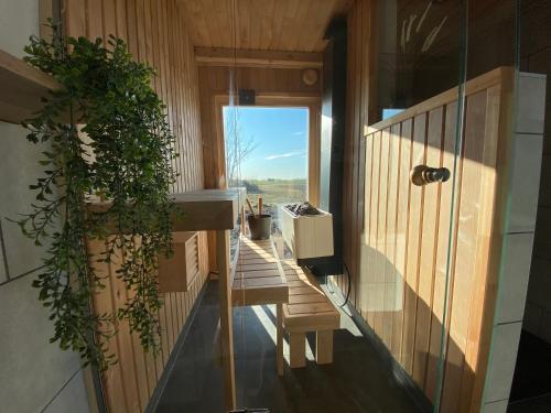 a room with a balcony with a bench and a window at Cozy house with sauna by the lake in Lokuti