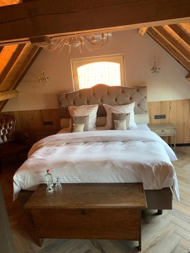 a bedroom with a large bed and a window at B&B De Rentmeesterhoeve in Reningelst