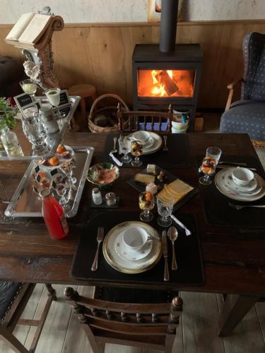 a table with plates of food and a fireplace at B&B De Rentmeesterhoeve in Reningelst