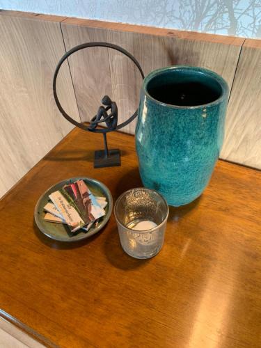 a blue vase on a table with a plate and a cup at B&B De Rentmeesterhoeve in Reningelst