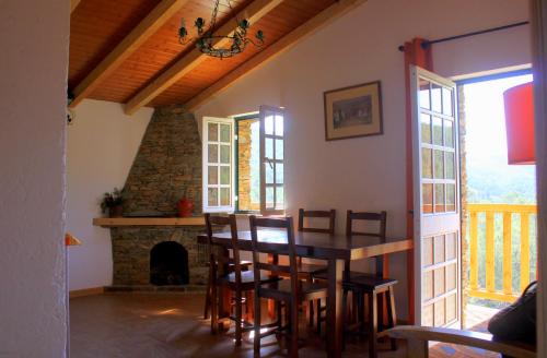 a dining room with a table and a fireplace at Retiro do Aguincho in Aguincho