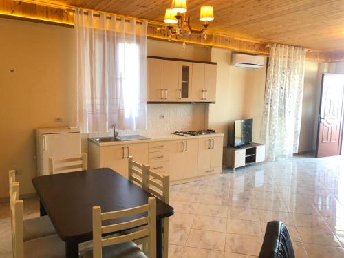 a kitchen and dining room with a table and chairs at The Sunset Villa Leven in Vlorë