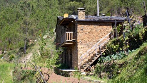 a small brick building with a balcony on a hill at Retiro do Aguincho in Aguincho